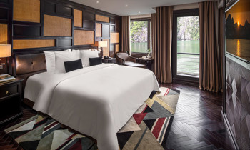 A room with double bed on the left, next to a window and door to the balcony.