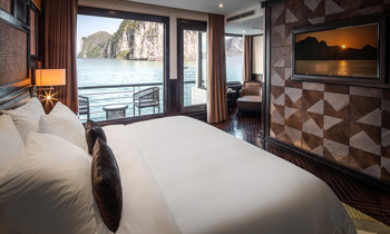 A room with double bed on the left, next to a window and door to the balcony.