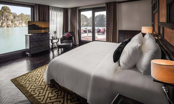 A room with double bed on the left, next to a window and door to the balcony.